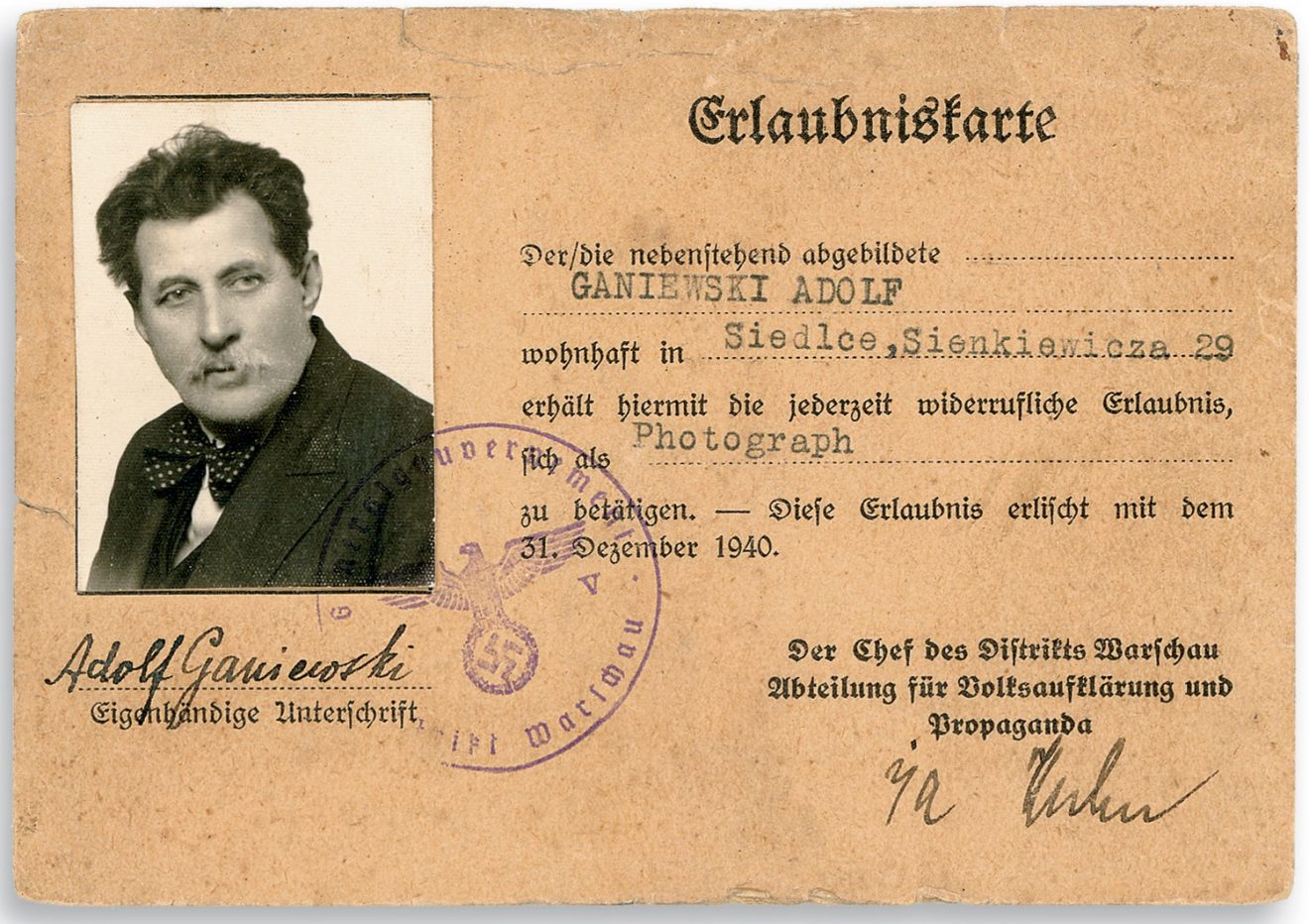 Dokument (karta pracy) z zdjęciem mężczyzny po lewej stronie oraz napisy i pieczęcie urzędowe w języku niemieckim