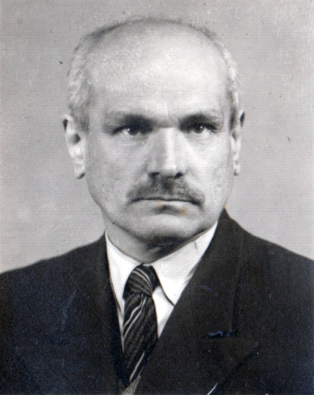 Fotografia wąsatego częściowo łysego mężczyzny ubranego w garnitur