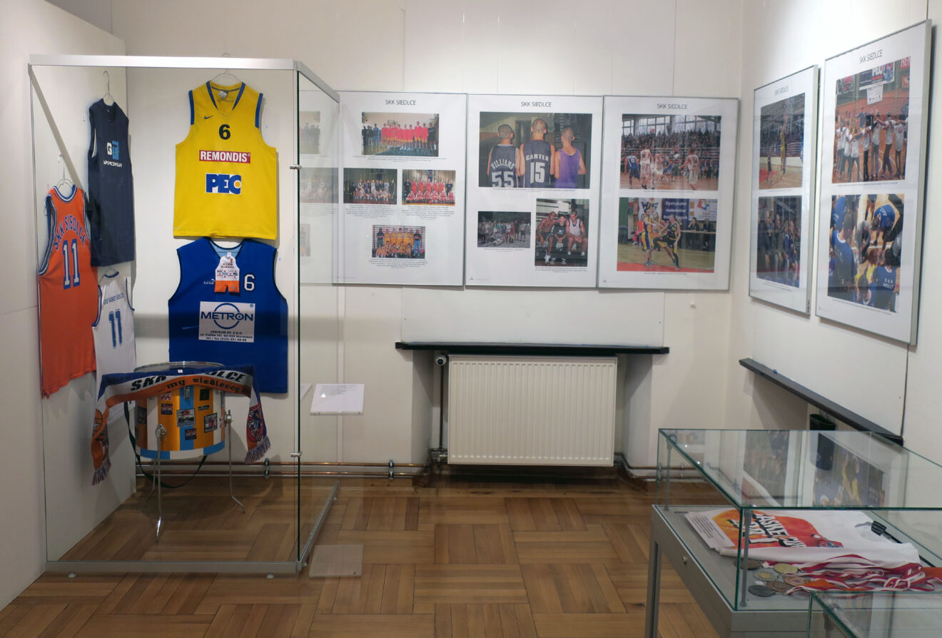 Fragment wystawy z planszami preznetującymi historię SKK Siedlce oraz koszulkami i pamiątkami z wydarzeń koszykarskich w Siedlcach.