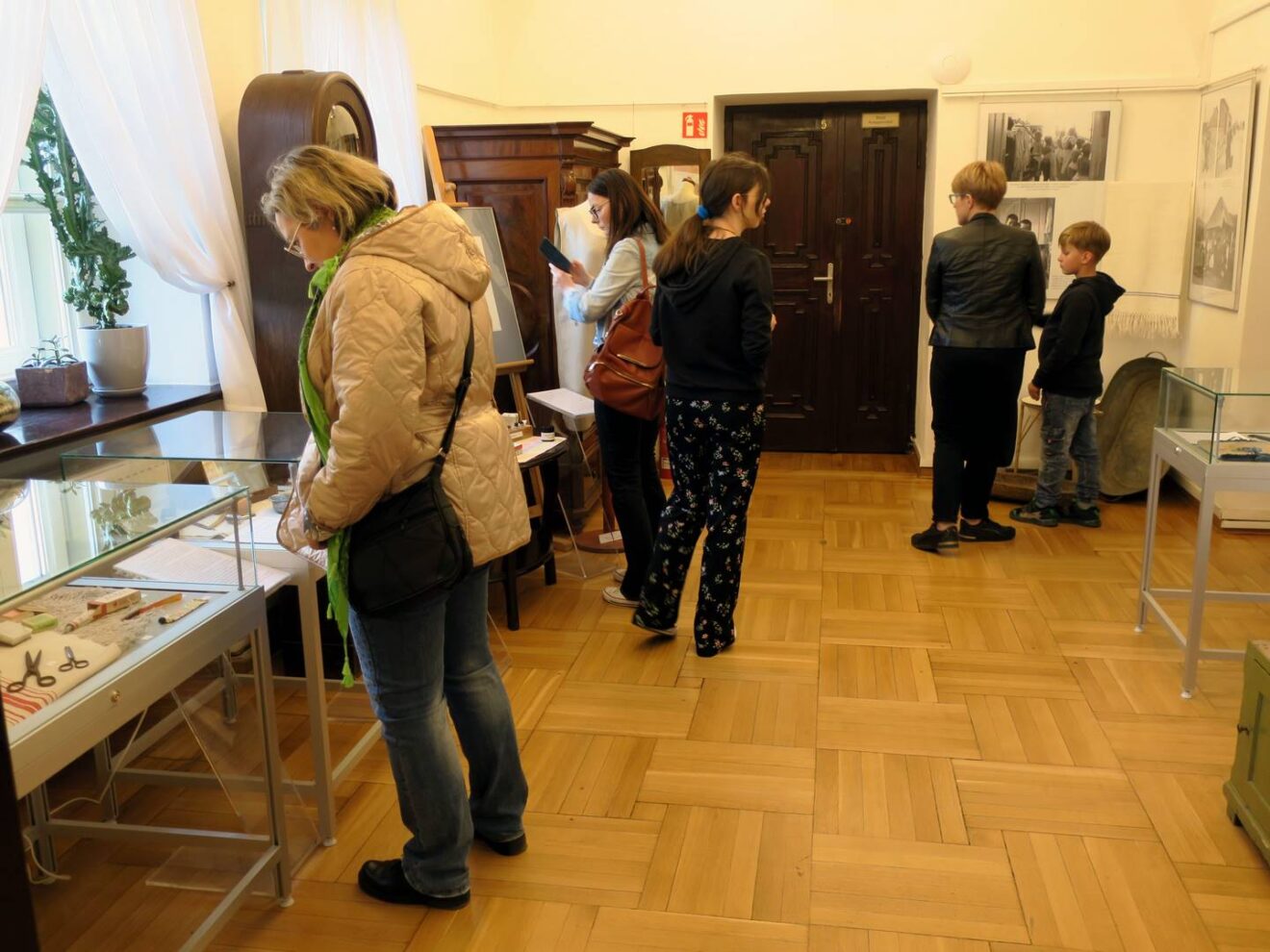 Grupa młodych osób zwiedzających ekspozycje muzealne.
